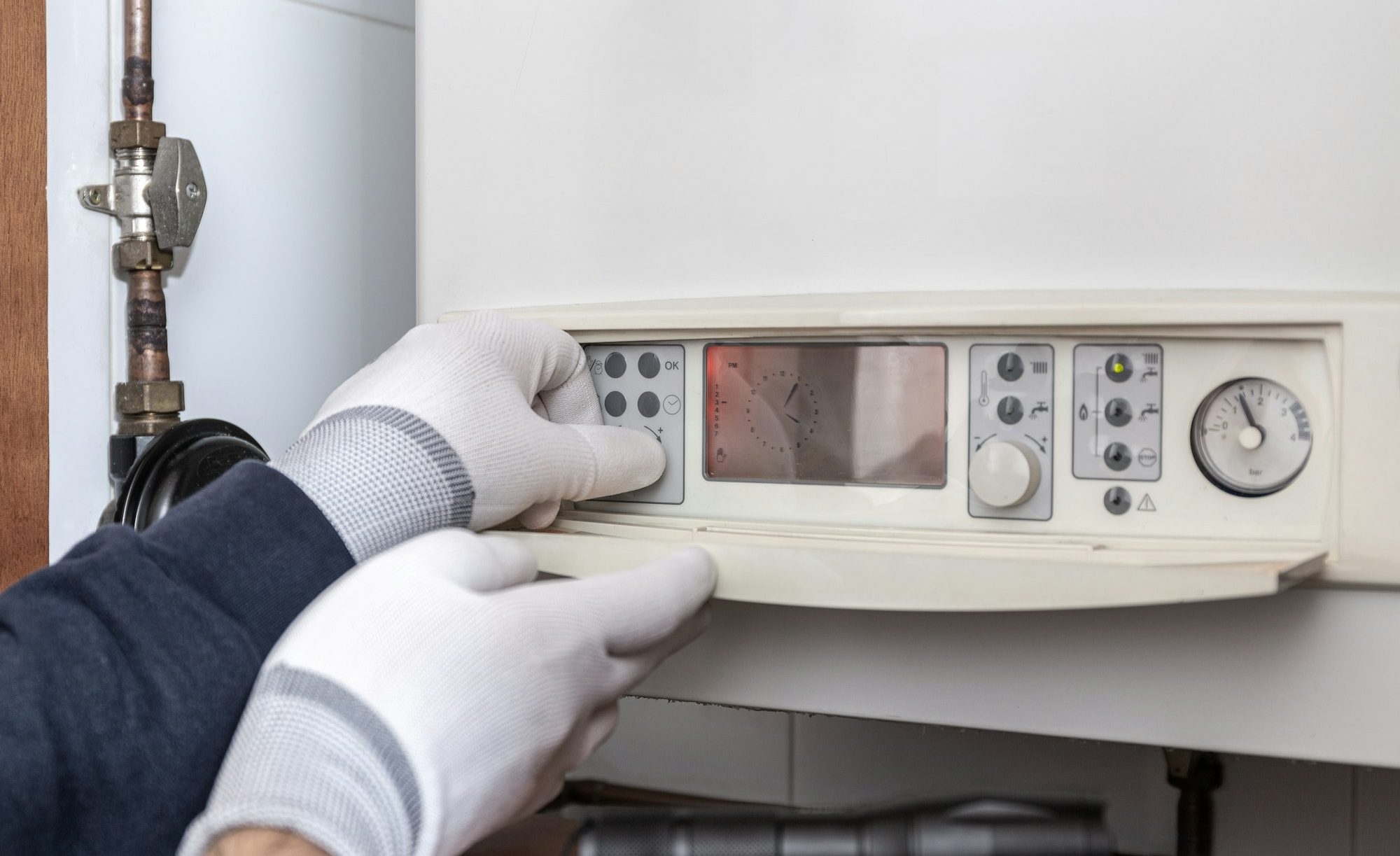 Technician servicing heating boiler in a house